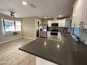 Bright kitchen features stainless appliances, white cabinets, dark countertops, and open floor plan at 9615 N 34Th Ave, Phoenix, AZ 85051