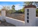 Entrance gate featuring a stucco column with decorative tile address numbers, set against a backdrop of desert foliage at 1044 E Irvine Rd, Phoenix, AZ 85086