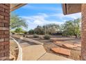 View of the desert landscaped front yard featuring decorative rocks, native plants, and a curving walkway to the entrance at 1044 E Irvine Rd, Phoenix, AZ 85086