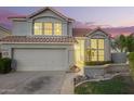 This two-story home features a tile roof, a well-manicured lawn, and large windows at 1405 N Jamaica Way, Gilbert, AZ 85234