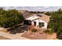 Aerial view of a charming home with a desert landscape, a two-car garage, and solar panels at 1432 E Penny Ln, San Tan Valley, AZ 85140