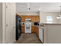 A well-lit kitchen showcases a breakfast bar, oak cabinets, and appliances including a black refrigerator at 1960 S Falcon Dr, Gilbert, AZ 85295