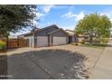 Wide driveway leading to this home with a gray exterior and a three-car garage at 20464 E Bronco Dr, Queen Creek, AZ 85142