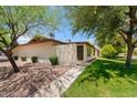 Well-maintained home featuring desert landscaping, mature trees, a lush lawn, and a private courtyard at 2064 S Farnsworth Dr # 43, Mesa, AZ 85209