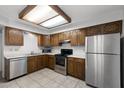 Efficient kitchen with stainless steel appliances, warm wood cabinetry, and tiled flooring for easy maintenance at 2064 S Farnsworth Dr # 43, Mesa, AZ 85209