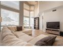 Comfortable living room with large windows, entertainment center, and wood flooring at 2117 E Saltsage Dr, Phoenix, AZ 85048