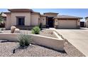 Desert-landscaped front yard featuring a low-wall border and a spacious driveway leading to a two-car garage at 2122 N Stapley Dr, Mesa, AZ 85203