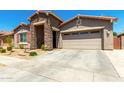 Inviting single-story home features a stone entrance, neutral stucco, and a two-car garage at 24013 N 165Th Ave, Surprise, AZ 85387
