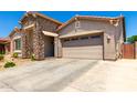 Well-maintained single-story home with stone accents, tan exterior, and a two-car garage at 24013 N 165Th Ave, Surprise, AZ 85387