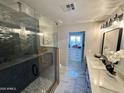 Modern bathroom features a glass shower, double vanity with marble countertops, and contemporary lighting at 2509 E Meadowbrook Ave, Phoenix, AZ 85016