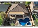 Aerial view of a private backyard oasis with a pool, spa, covered patio, and desert landscaping at 4413 W Phalen Dr, New River, AZ 85087