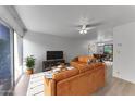 Comfortable living room with large windows, TV, hardwood floors, and dining room in background at 4630 N 68Th St # 280, Scottsdale, AZ 85251