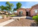 Charming single-story home with desert landscaping, green trees and a well-manicured lawn in the neighborhood at 4662 S Calico Rd, Gilbert, AZ 85297
