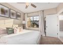 Bright bedroom with a large window, plush carpeting, and neutral decor at 5302 E Van Buren St # 2024, Phoenix, AZ 85008