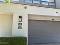 Exterior view of home featuring a two-car garage and address number at 7222 E Gainey Ranch Rd # 232, Scottsdale, AZ 85258