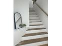 Elegant staircase featuring wood treads, white risers, and a minimalist design at 7222 E Gainey Ranch Rd # 232, Scottsdale, AZ 85258