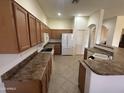 A large kitchen with a tile floor, wooden cabinets, white appliances, and a breakfast bar at 7227 W Paradise Ln, Peoria, AZ 85382