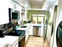 Modern kitchen boasts stainless steel appliances, white cabinets, and a bright window with lovely green plants at 841 E Peoria Ave # 2, Phoenix, AZ 85020