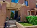 Cozy outdoor patio with textured walls offers a serene space with artificial grass and a sliding glass door at 841 E Peoria Ave # 2, Phoenix, AZ 85020