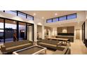Open-concept living area featuring sleek sofas, dining space, modern lighting, and expansive windows for natural light at 8618 E Irish Hunter Trl, Scottsdale, AZ 85258