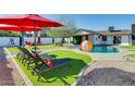 Inviting backyard with pool, lounge chairs, and artificial turf perfect for outdoor entertaining at 1027 S Siesta Ln, Tempe, AZ 85281