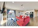 Bright living room featuring a red sectional sofa, hardwood floors, and a view of the pool at 1027 S Siesta Ln, Tempe, AZ 85281