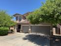 Charming two-story home featuring a three-car garage and mature landscaping at 10430 W Los Gatos Dr, Peoria, AZ 85383