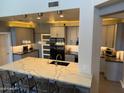 Modern kitchen featuring a large island with a white countertop and gray cabinets and stainless steel appliances at 10430 W Los Gatos Dr, Peoria, AZ 85383