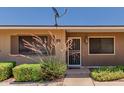 Inviting front entrance with security screen door and well-maintained landscaping at 10520 W Coggins Dr, Sun City, AZ 85351