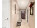 Inviting entryway featuring neutral-toned walls, tiled floor, and a charming wooden bench at 10820 N 45Th Dr, Glendale, AZ 85304