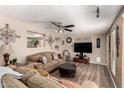 Cozy living room showcasing hardwood floors, a ceiling fan, and an opening through to the kitchen at 10820 N 45Th Dr, Glendale, AZ 85304