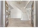 Grand foyer with a staircase and chandelier exudes elegance, with wood floors at 11089 N 130Th Pl, Scottsdale, AZ 85259