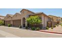Beige two-story home with a two-car garage, tile roof, and desert-friendly landscaping, offering charming curb appeal at 1255 N Arizona Ave # 1300, Chandler, AZ 85225