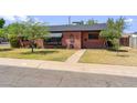 Cozy home with awning, decorative wrought iron and tidy landscaping at 2020 W Marshall Ave, Phoenix, AZ 85015