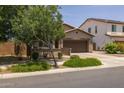 Inviting single-story home with lush front lawn and landscaping, paired with a spacious two-car garage for modern suburban living at 20904 E Swan Dr, Queen Creek, AZ 85142