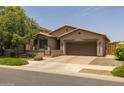 Inviting single-story home with lush front lawn and landscaping, paired with a spacious two-car garage for modern suburban living at 20904 E Swan Dr, Queen Creek, AZ 85142