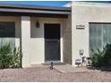 Inviting entrance to home featuring a black security door and manicured landscaping at 211 Bahia E Ln, Litchfield Park, AZ 85340