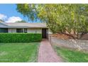 Inviting front yard with a brick walkway leading to a charming home entrance with manicured shrubs at 216 E Harmont Dr, Phoenix, AZ 85020