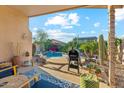 Inviting backyard patio with BBQ, outdoor seating, sparkling pool, and lush desert landscaping for serene relaxation at 2432 W Oberlin Way, Phoenix, AZ 85085