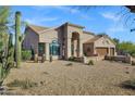 Desert-style house with three-car garage and beautiful desert plants at 26475 N Wrangler Rd, Scottsdale, AZ 85255