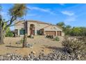Beautiful home with desert landscaping and a three-car garage at 26475 N Wrangler Rd, Scottsdale, AZ 85255