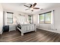 Comfortable bedroom with a ceiling fan, wood-style floors, and natural light from two windows at 278 S San Luis Rey Trl, Casa Grande, AZ 85194