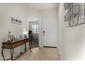 Bright entryway with neutral tile flooring, a decorative table, and a view into the next room at 3026 N 305Th Dr, Buckeye, AZ 85396
