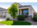 Charming exterior with tidy desert landscaping, a green lawn accent, and a covered porch area at 3026 N 305Th Dr, Buckeye, AZ 85396