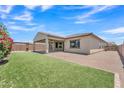 Expansive backyard featuring a covered patio, artificial grass, and desert landscaping, ideal for outdoor entertaining at 4866 N 185-Th Dr, Goodyear, AZ 85395