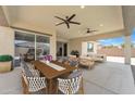 This covered patio features ample seating, ceiling fans, and sliding glass doors for indoor/outdoor living at 4866 N 185-Th Dr, Goodyear, AZ 85395