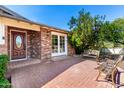 Inviting brick patio with outdoor seating, leading to a wooden front door and french windows, showcasing a charming exterior at 5744 E Oak St, Scottsdale, AZ 85257