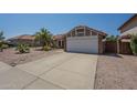 Charming single-story home featuring a driveway, desert landscaping and a two-car garage at 5911 E Evergreen St, Mesa, AZ 85205