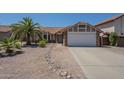 Charming single-story home with desert landscaping and a spacious two-car garage and a red tile roof at 5911 E Evergreen St, Mesa, AZ 85205