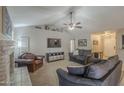Cozy living room with a ceiling fan, carpet floors, a TV, and a brick fireplace at 5911 E Evergreen St, Mesa, AZ 85205